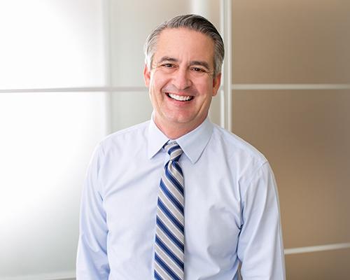 older man in a tie smiling