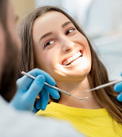 woman at checkup smiles at her Center dentist