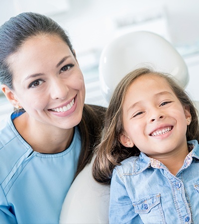 Smiling child and dentla team member in exam room