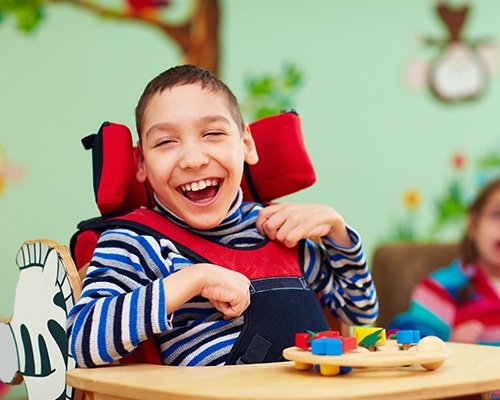 Laughing young boy in wheelchair