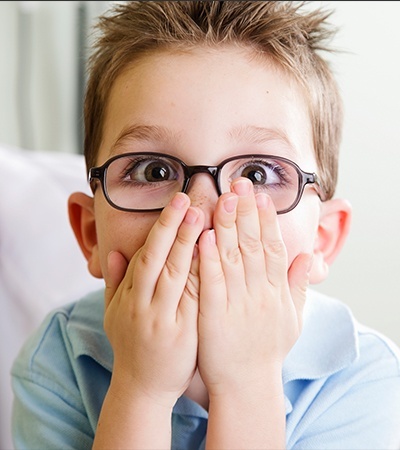 Little boy covering his mouth