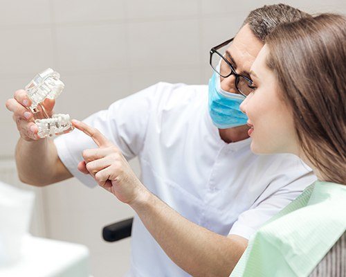 Dentist showing patient implant supported fixed bridge model