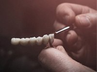 Man painting replacement teeth