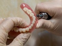 Lab technician shaping dentures