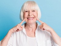 Woman pointing to her smile