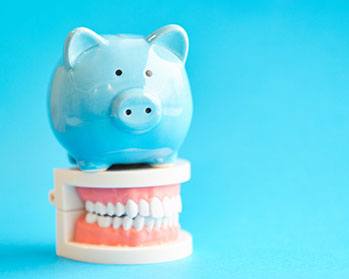 Blue piggy bank on top of dentures in Center