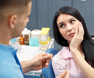 Woman with toothache in center visiting her Center emergency dentist