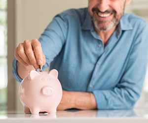 Man with piggy bank saving up for toothache treatment in Center