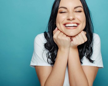 Woman smiling after visiting emergency dental office in Center