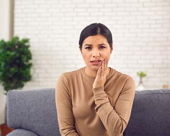 Woman in need of an emergency dentist in Center