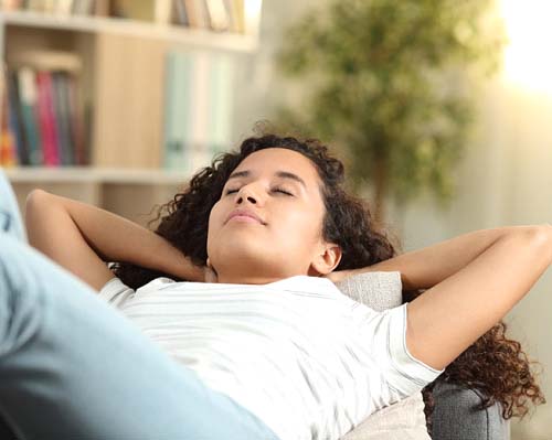 Woman resting with head elevated after tooth extraction in Center