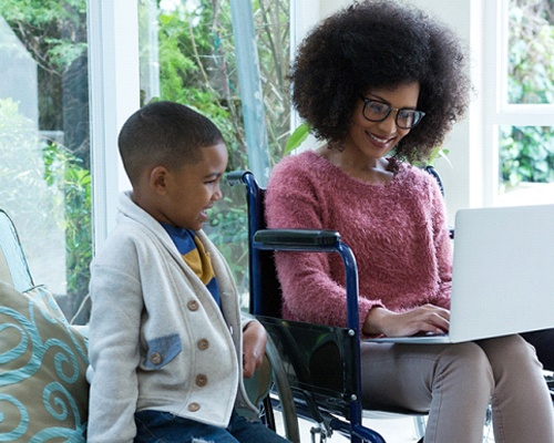 a parent and child researching family dentist’s on a laptop