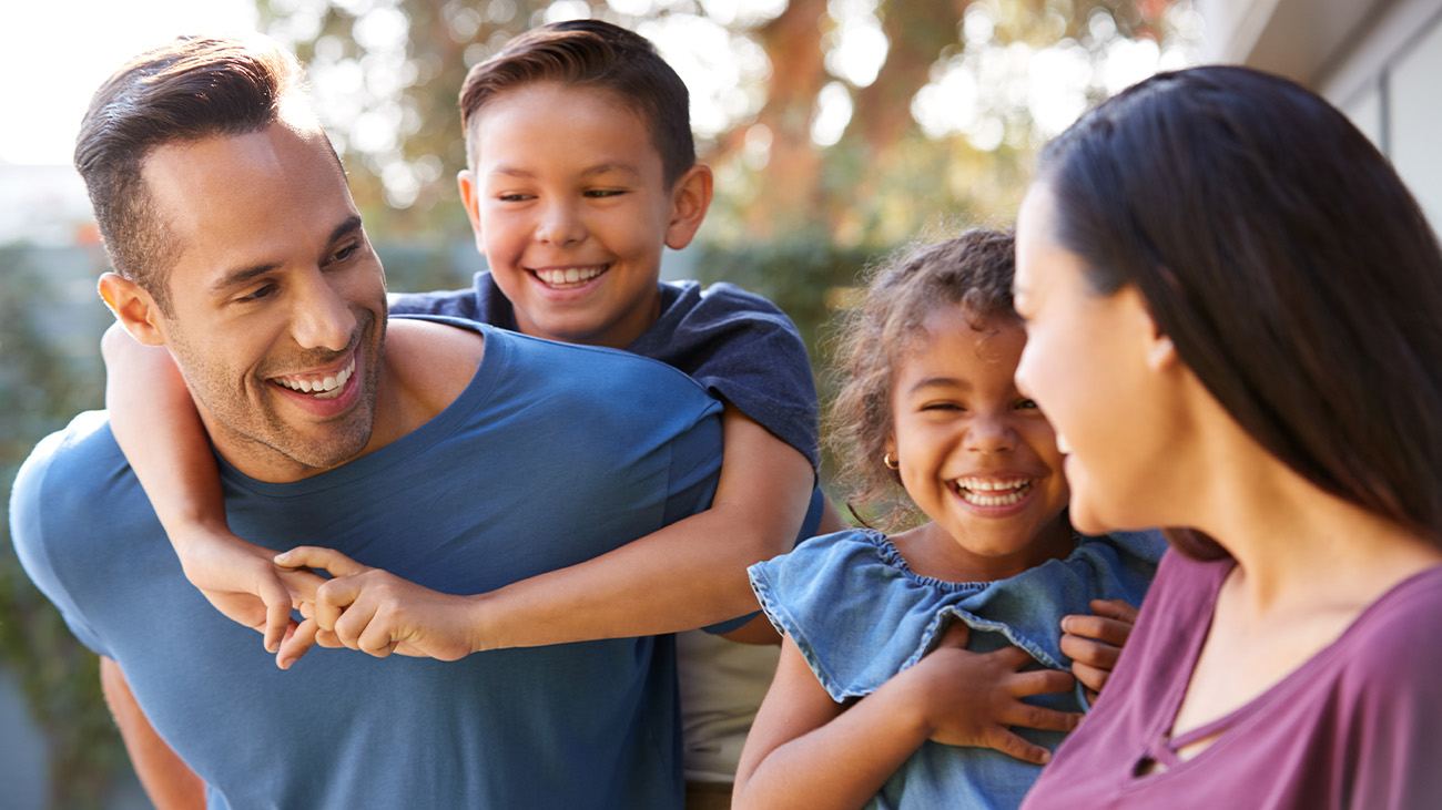 Family of four smiling and laughing outdoors