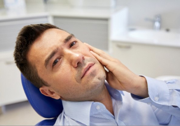 woman holding mouth in pain in Family Dental Center of East Texas   