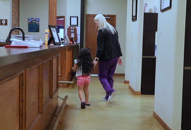 Mother and daughter going to dental exam room