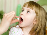 Parent giving child pill before dentist’s appointment