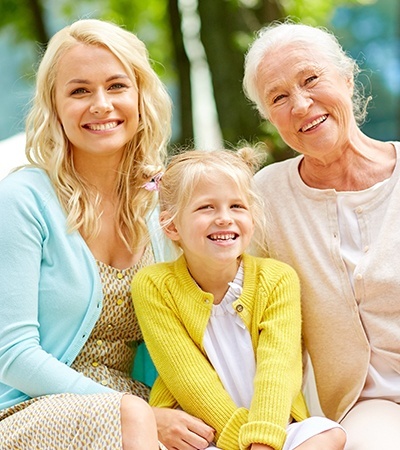 Mother daughter and granddaughter smiling together outdoors