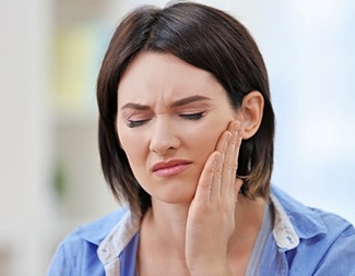 Woman in pain holding jaw