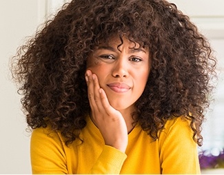 Woman holding cheek in pain