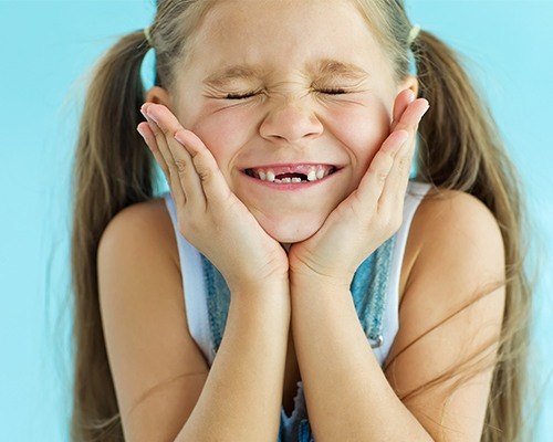 Smiling little girl with missing top front teeth