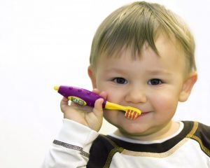 baby holding a toothbrush
