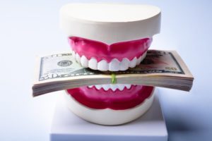 model of a mouth biting down on money