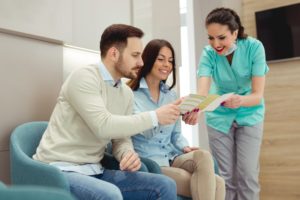 dentist in Center explaining dental insurance to two patients 