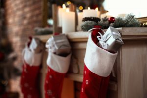 red stockings on the mantle with silver gifts inside of them 