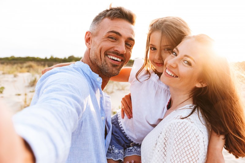 family smiling with white teeth during summer vacation