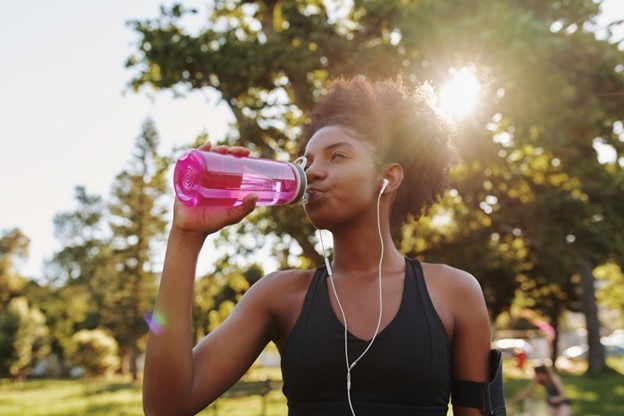 Woman drinking water to stay hydrated.