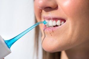 woman using water flosser