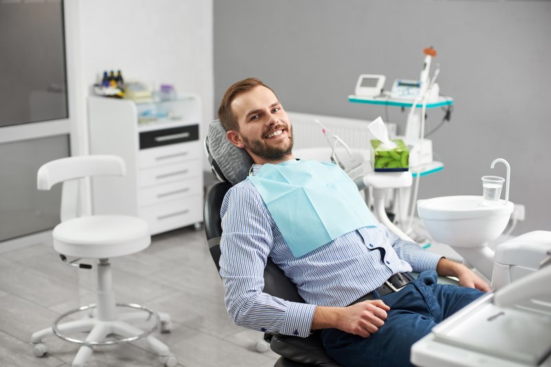 A happy dental patient sitting in a chair
