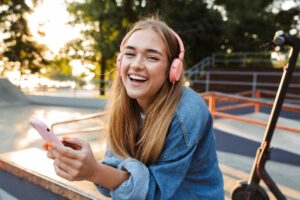 Teen girl smiling and listening to music.