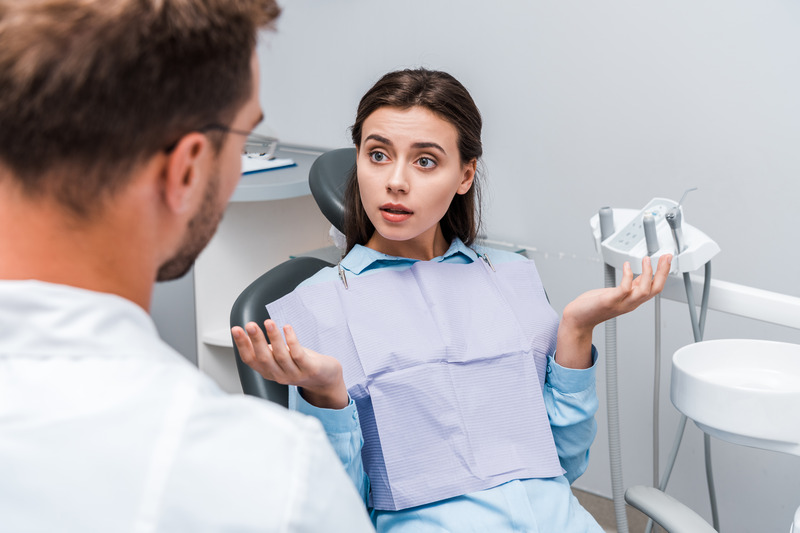 Patient asking dentist about loose dental bridge
