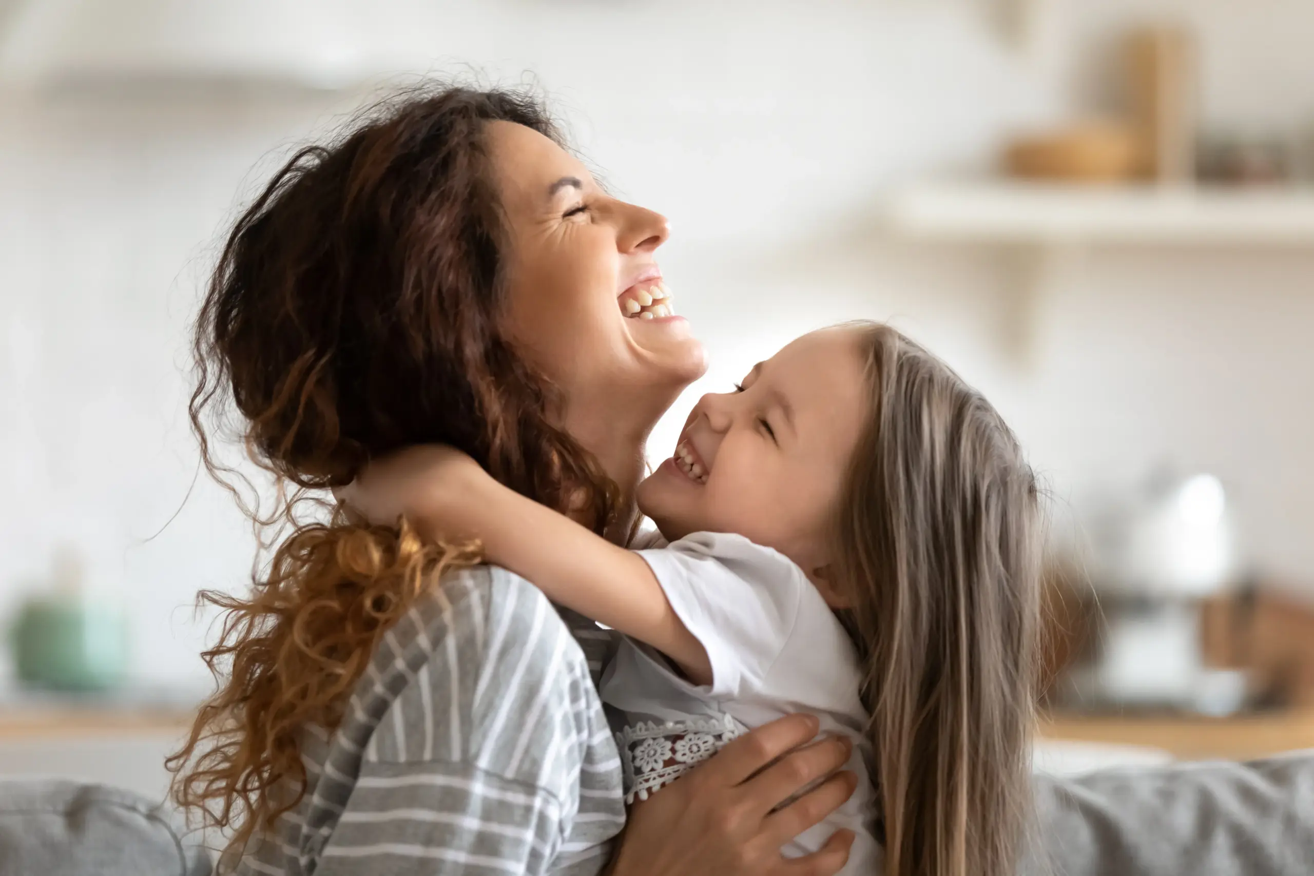 Mother hugging child showing healthy family smiles in Center TX