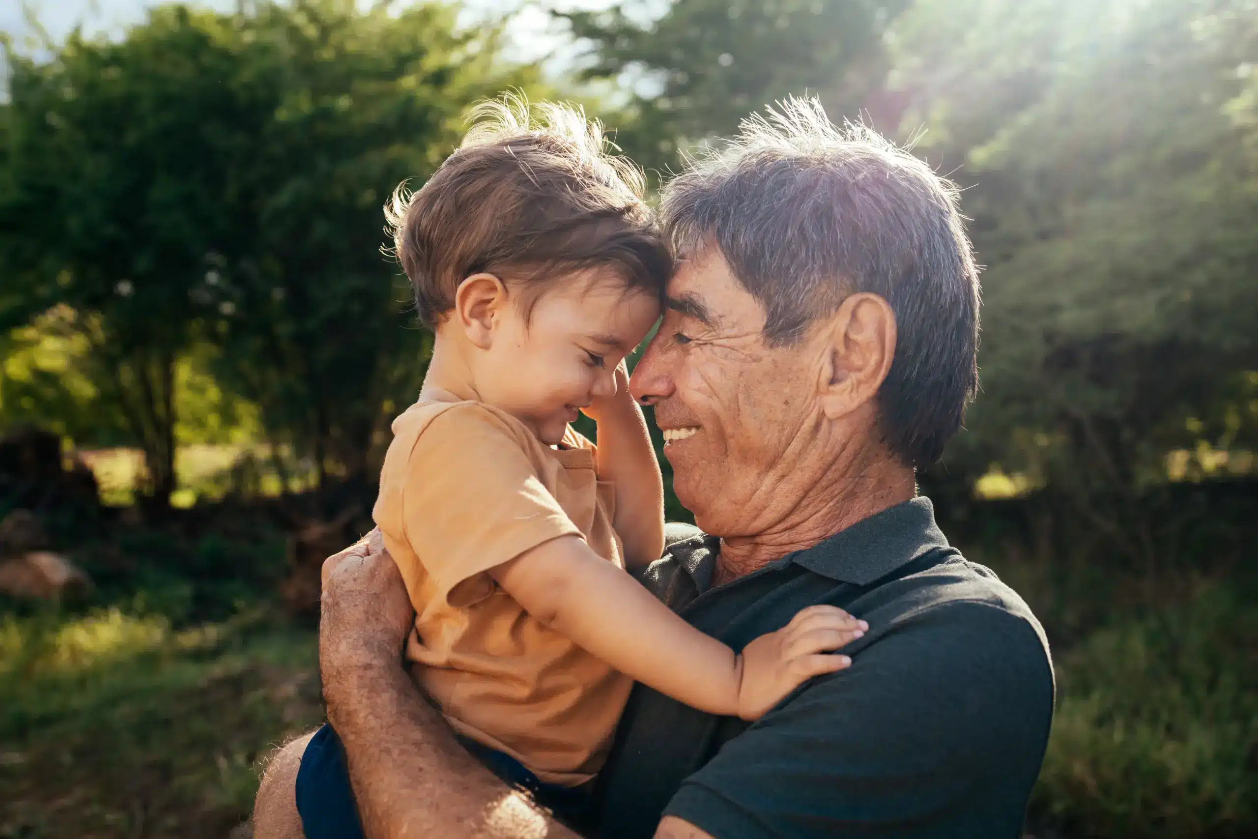 Grandfather holding child smiling at family dentist in Center TX