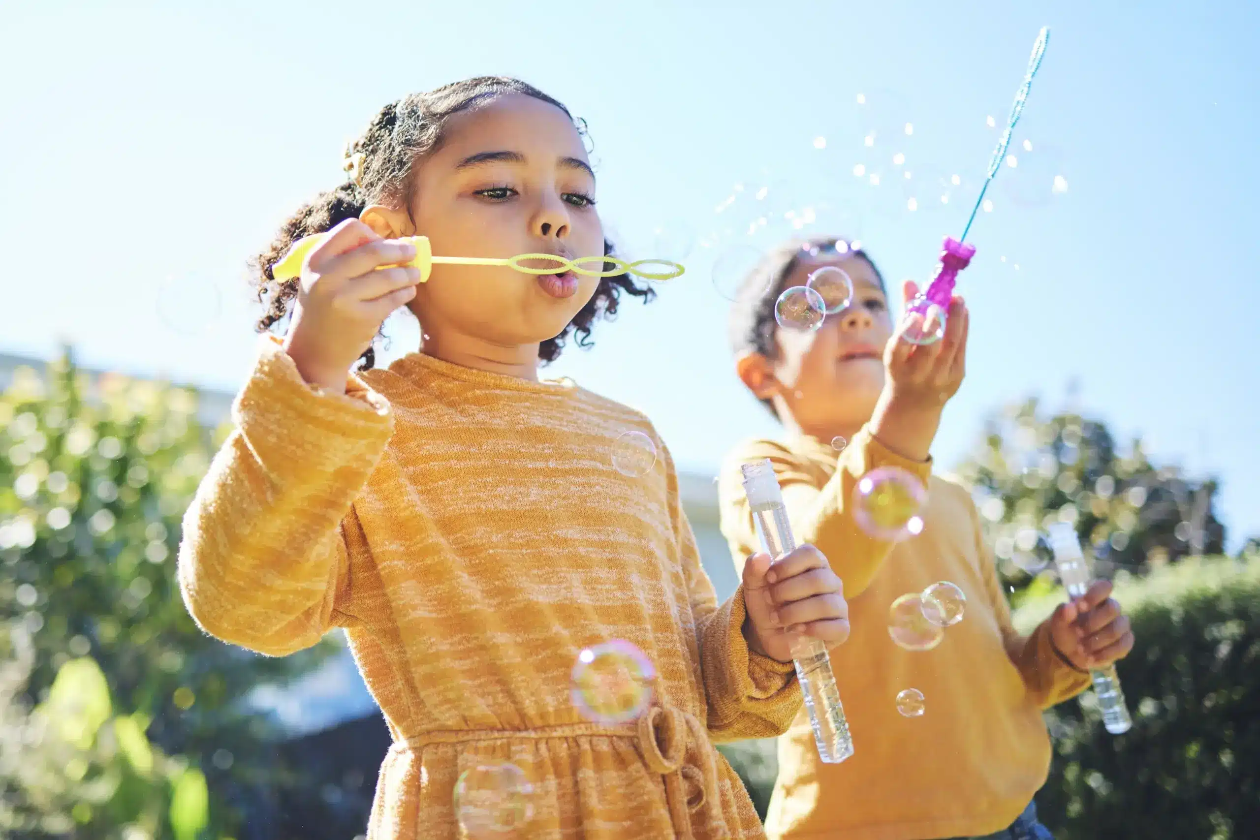 Children playing outdoors smiling with healthy teeth in Center TX