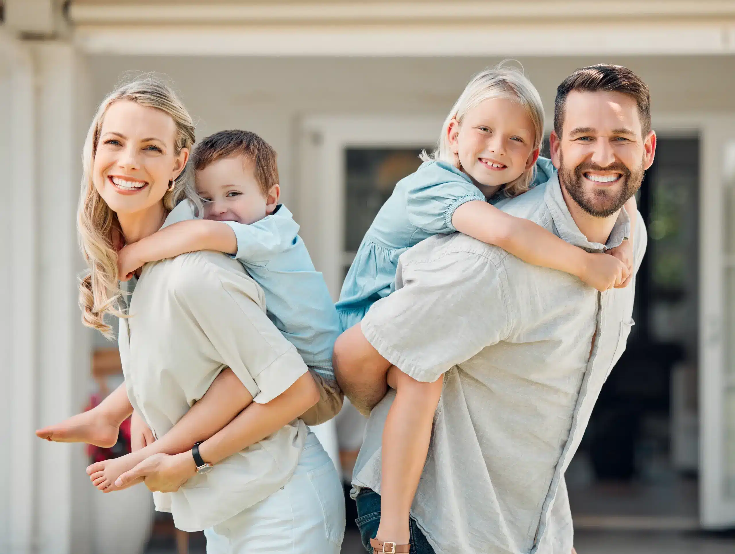 Parents carrying child smiling outside family dental office in Center TX