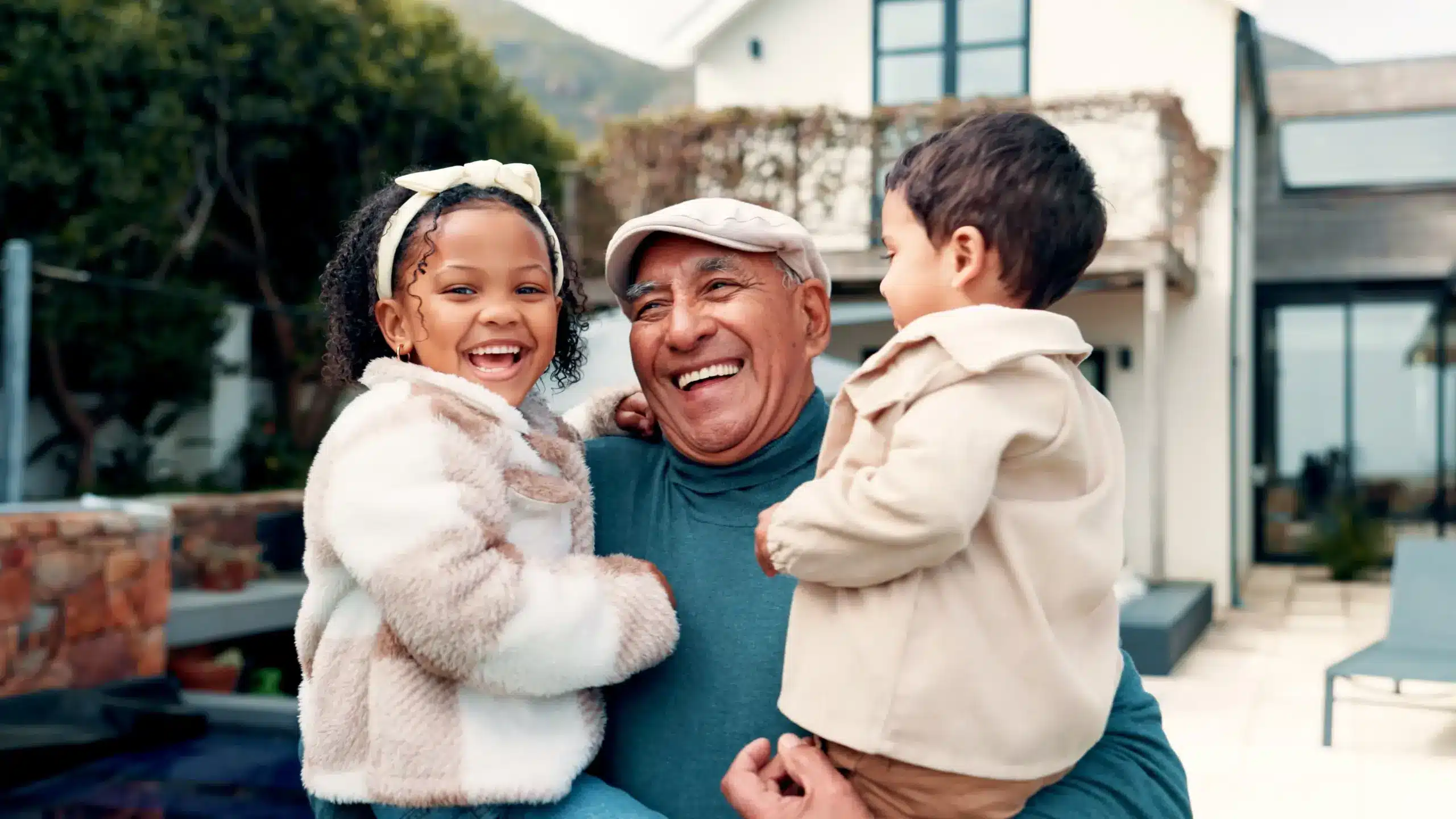 Grandfather holding grandchildren smiling with healthy teeth after Children's Sedation Dentistry in Center TX