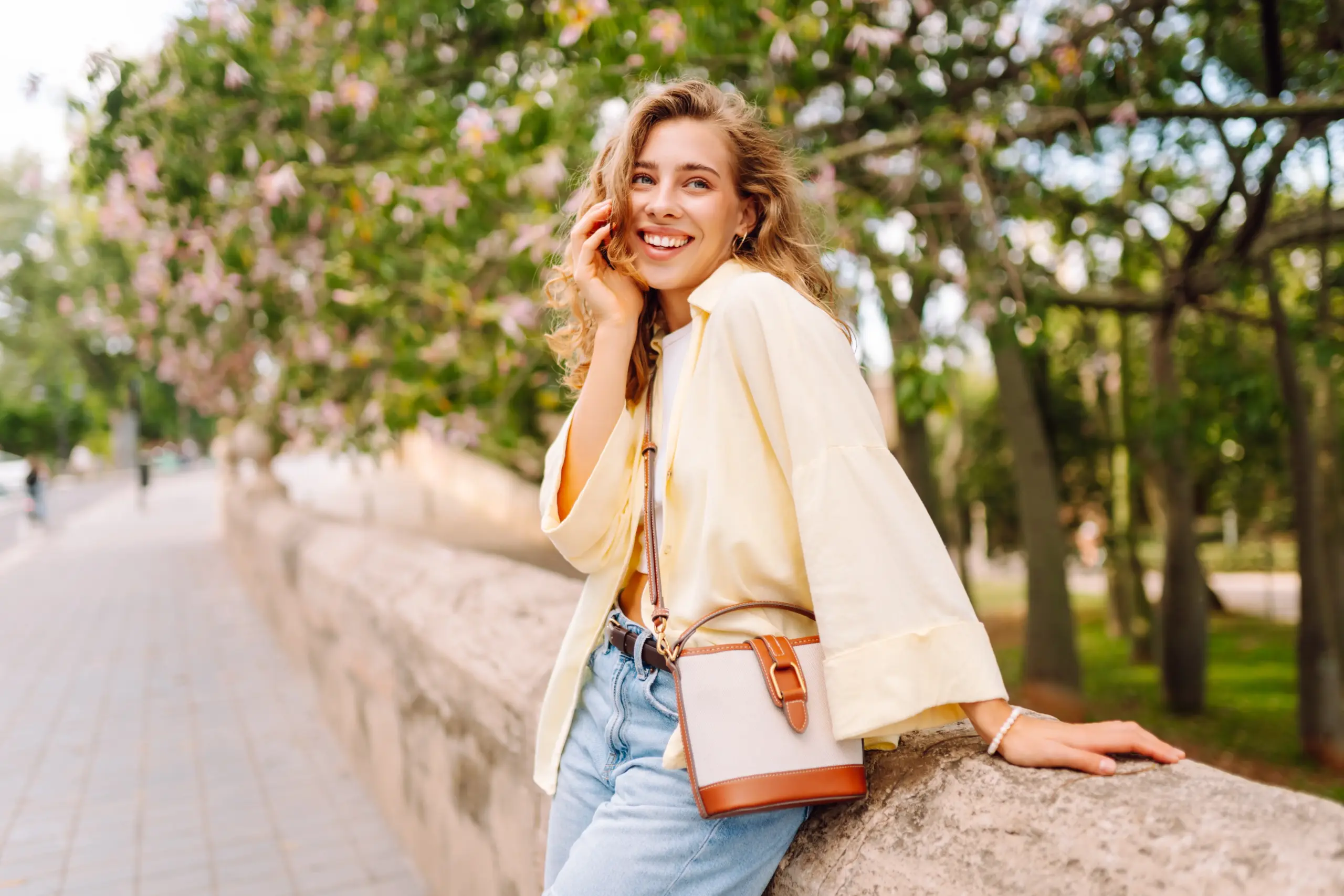Young woman smiling outdoors with healthy looking teeth after Dental Bonding in Center TX